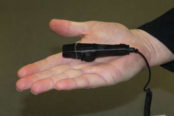 A police officer displays an example of a body camera. Photo: Renata Sago, WMFE