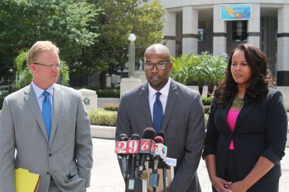 Photo: Attorney Patrick Lawlor; Noel Carter; Attorney Natalie Jackson speak at a press conference in front of the Orange County courthouse.