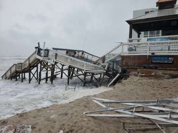 Chases on the Beach’s deck collapses into New Smyrna Beach as Hurricane Nicole’s storm surge sweeps the sand dunes from underneath.